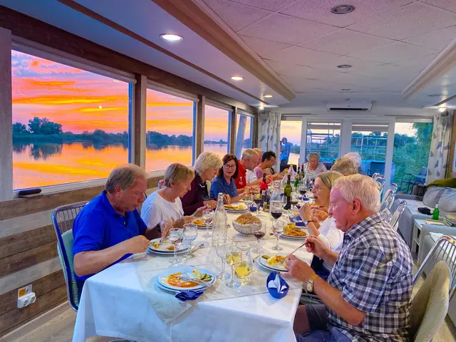 Panoramic dining salon on Ibis Tours floating hotel with breakfast table and Danube Delta canal view